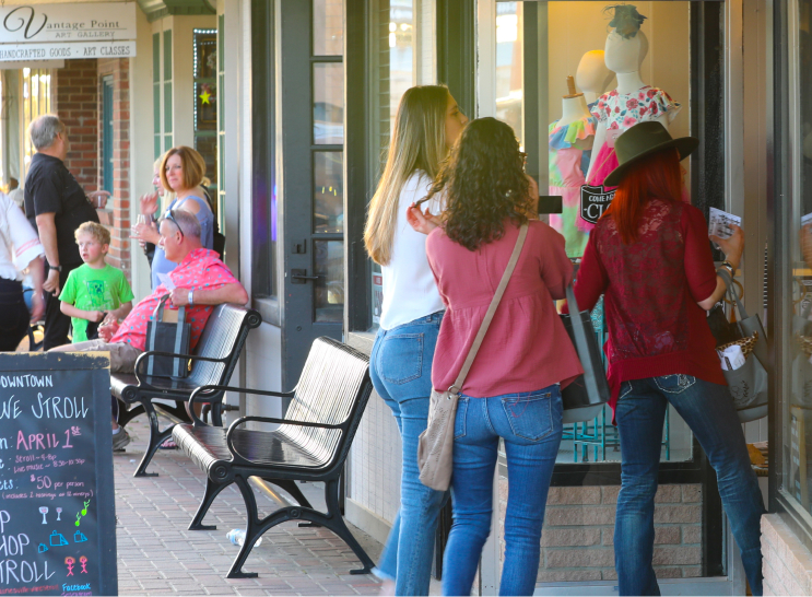 Photo of shoppers looking into store windows on the downtown strip