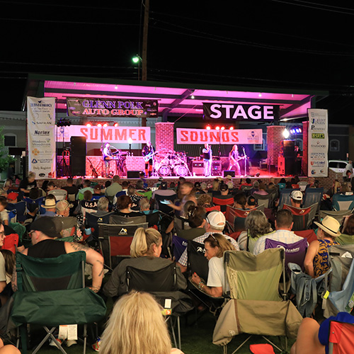 Photo at night of a music event going on at a local outdoor stage
