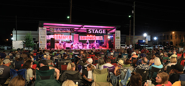 Photo at night of a music event happening at a local outdoor stage