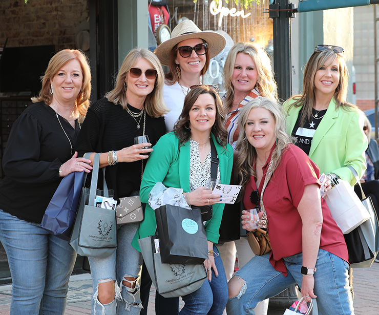 ttd-blue-section-img-desktop A group of women posing outside of a shop on main street