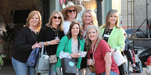 ttd-blue-section-img-mobile A group of women posing outside of a shop on main street
